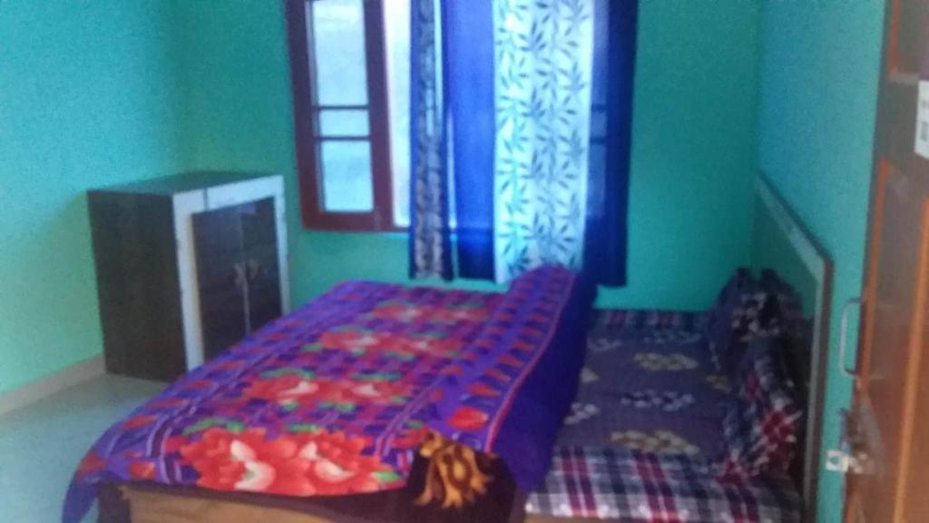 a bedroom with a bed and a window at SPOT ON Sharma's Kitchen & Home Stay in Bajaura