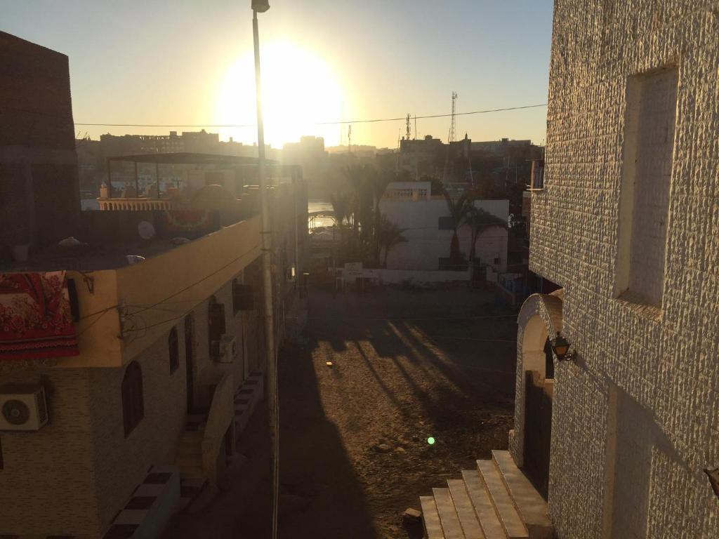 un tramonto dietro un edificio con il tramonto di Elephantine Hostel a Aswan