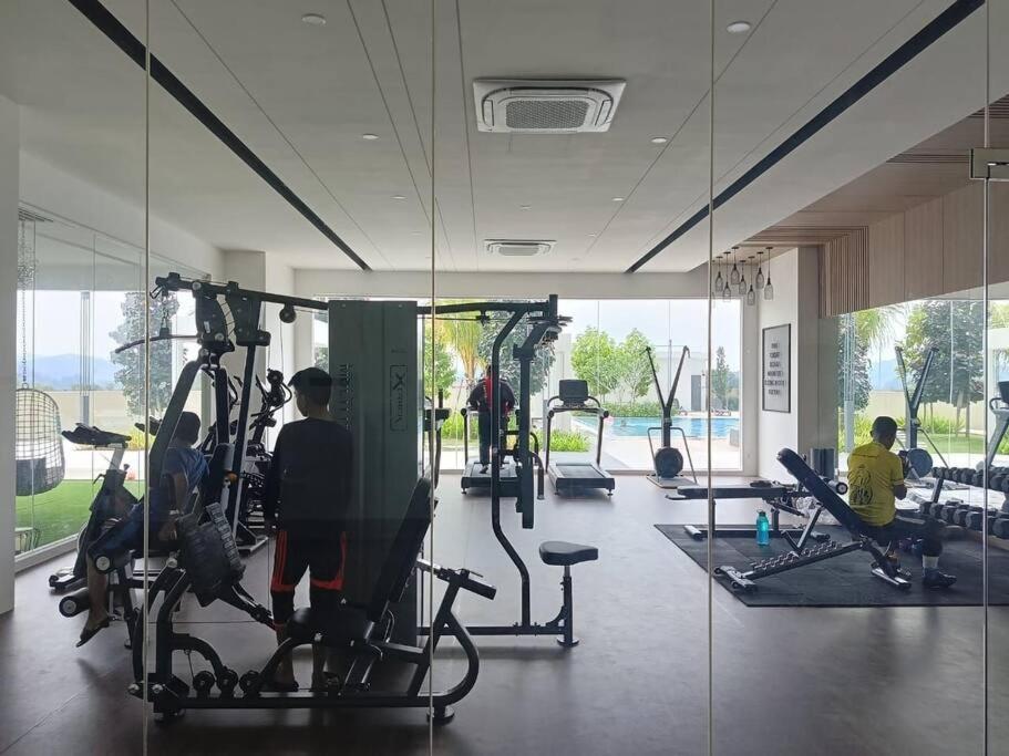 a gym with several treadying machines and a mirror at Tamu @ Ostia Bangi in Bangi