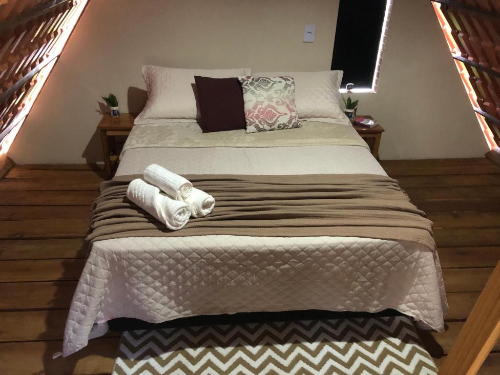 Una cama con dos toallas en una habitación en Chalé das Montanhas, en Caparaó Velho