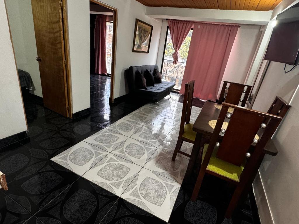 uma sala de estar com um sofá, uma mesa e cadeiras em Aparta Suite Torre De Prado 401 em Medellín