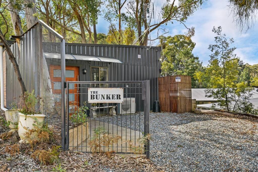 a gate with a sign in front of a building at The Bunker - Orange, NSW in Mullion Creek
