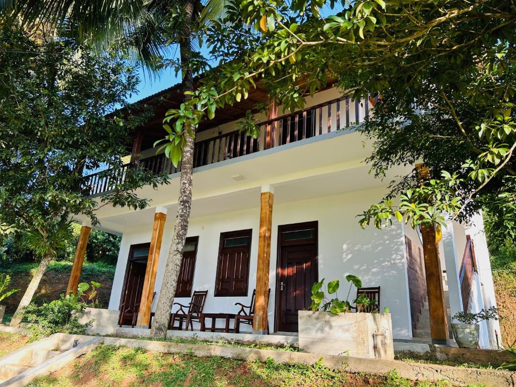 uma casa com duas cadeiras em frente em Hari Villa Mirissa em Mirissa