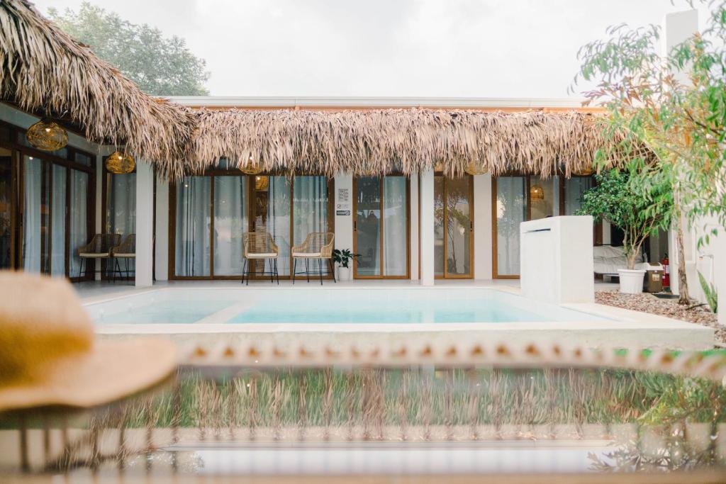 un resort con piscina e tetto di paglia di Private Villa with Pool in Vigan, Ilocos Sur - Selene Private Villas a San Vincente