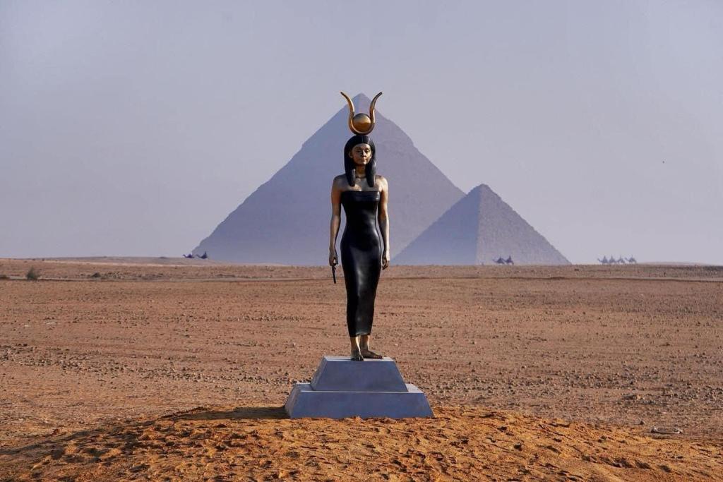 uma estátua de uma mulher em frente às pirâmides em Momen Pyramids Inn no Cairo