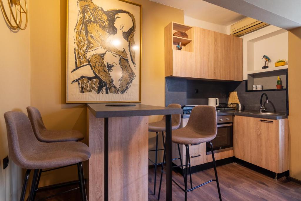 een keuken met een bar met krukken erin bij • Skopje Downtown ǀ 2 Bedrooms ǀ Parking • in Skopje