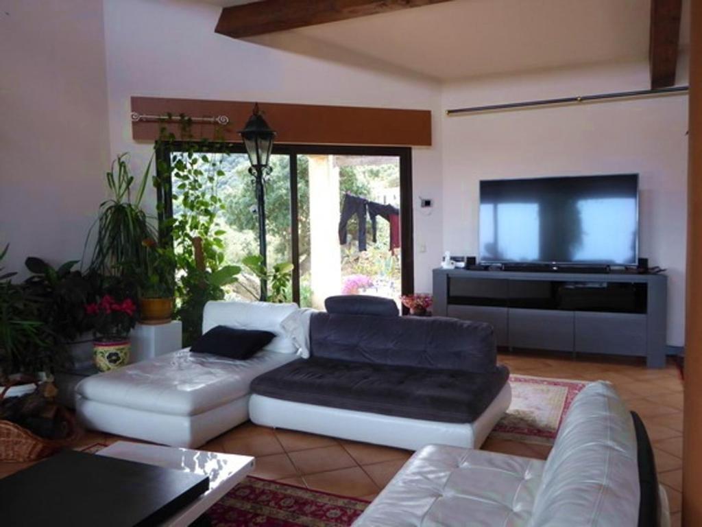 a living room with two couches and a flat screen tv at Villa Sorède, 4 pièces, 6 personnes - FR-1-776-11 in Sorède