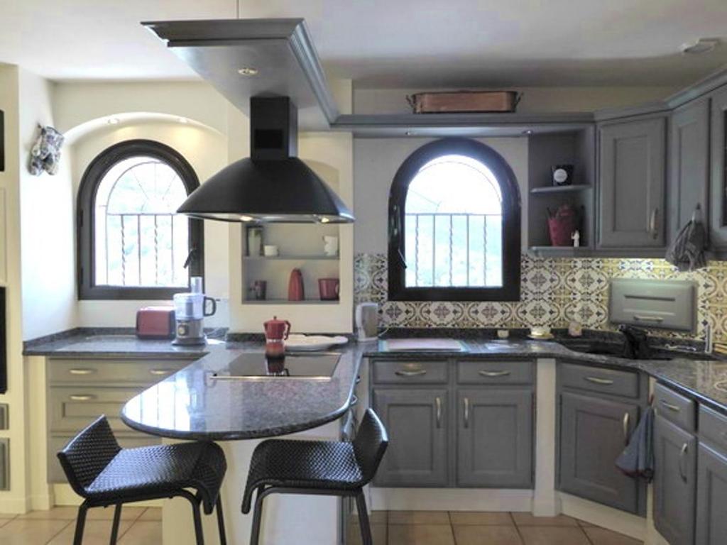 a kitchen with gray cabinets and a table and chairs at Villa Sorède, 4 pièces, 6 personnes - FR-1-776-11 in Sorède