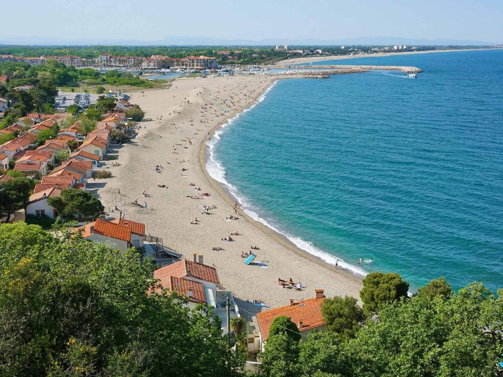 a beach with people on the sand and water at Villa Sorède, 4 pièces, 6 personnes - FR-1-776-11 in Sorède