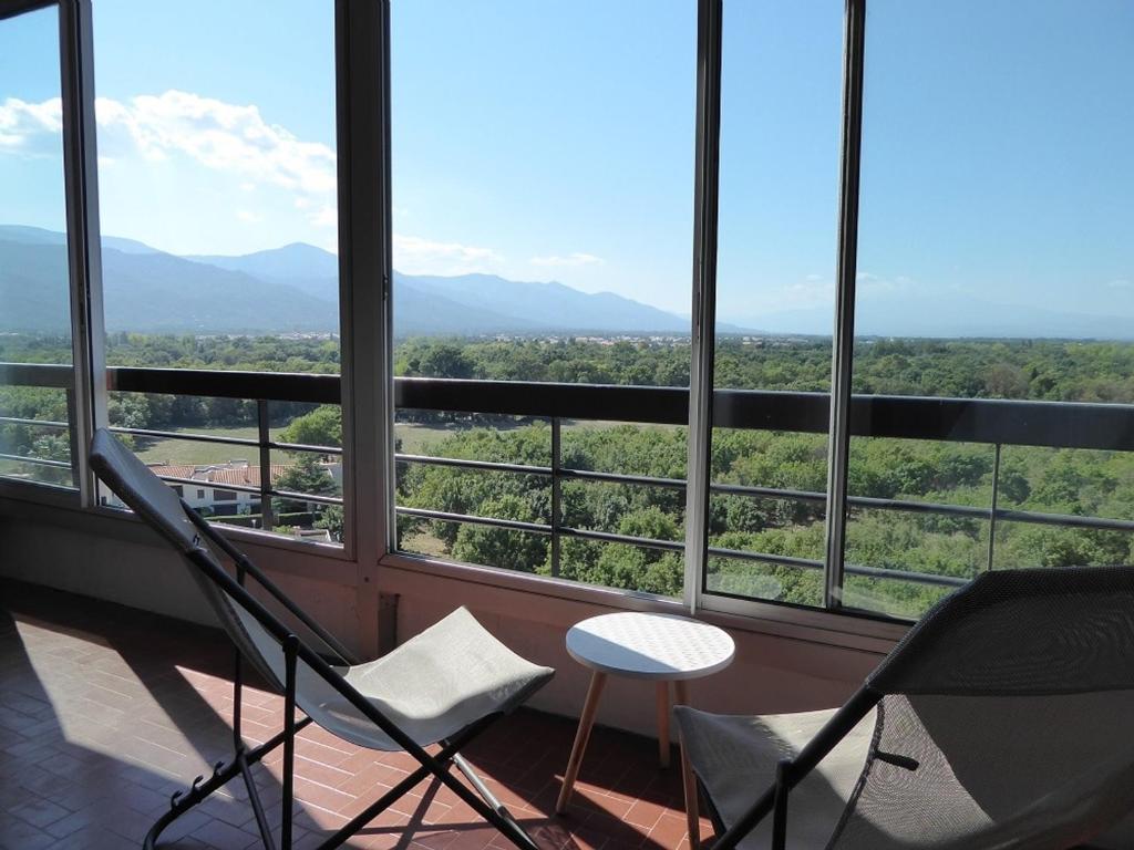 a balcony with chairs and a view of the mountains at Appartement Argelès-sur-Mer, 1 pièce, 4 personnes - FR-1-776-39 in Argelès-sur-Mer