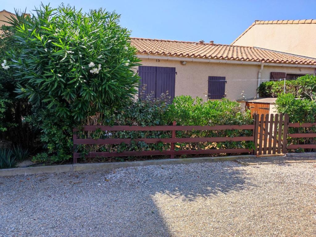 une clôture en bois devant une maison dans l'établissement Pavillon cosy 4 pers, 500m plage, jardinet, proche commerces, parking sécurisé - FR-1-776-13, à Argelès-sur-Mer