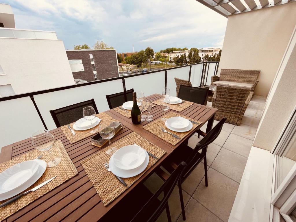 - une table sur un balcon avec une bouteille de vin dans l'établissement Superbe Appartement 6 Pers. à Argelès: Terrasse, WIFI, Parking, Proche Plage - FR-1-776-25, à Argelès-sur-Mer