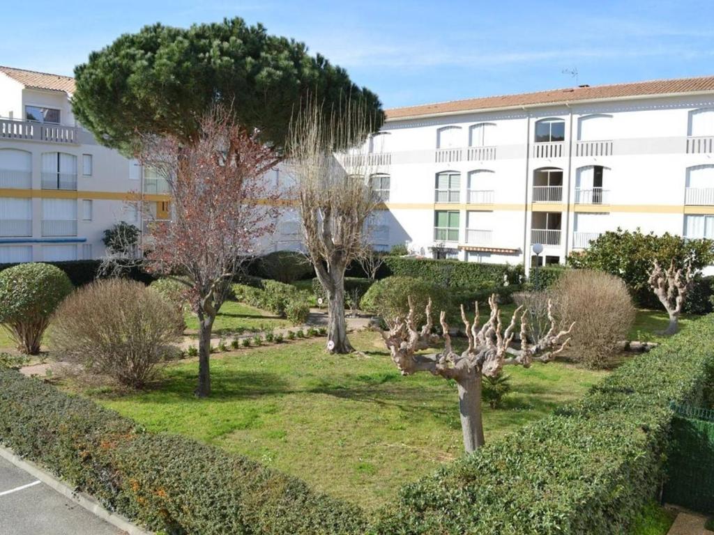 a park with trees and bushes in front of a building at Studio Argelès-sur-Mer, 1 pièce, 4 personnes - FR-1-776-63 in Foix