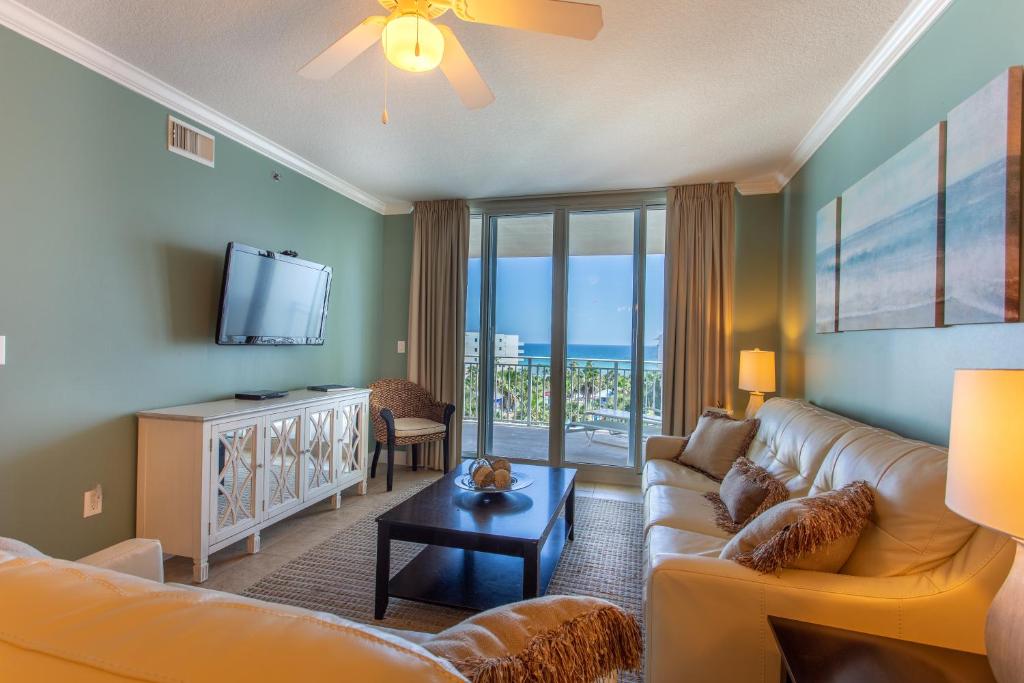 a living room with a couch and a tv at Waterscape C605 - Top Floor Beach Views - Free Beach Service - Interior Facing! in Fort Walton Beach