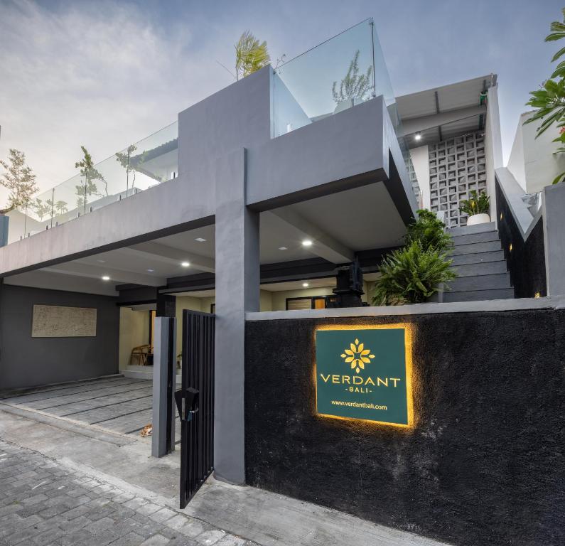 a modern house with a yellow sign in front of it at Verdant Bali Sekar Sari in Denpasar