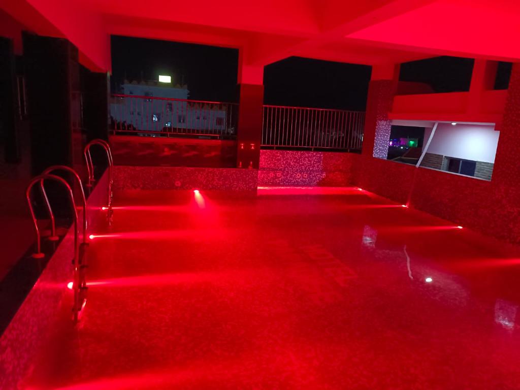 una habitación roja vacía con luces rojas y sillas en Hotel Paradise, en Mandarmani