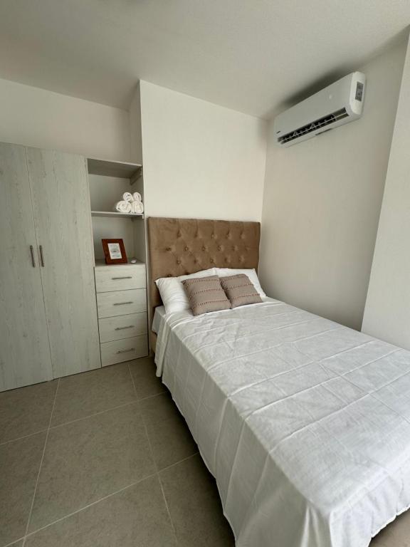 a bedroom with a large bed and a air conditioner at Punta Blanca Apt in Punta Blanca