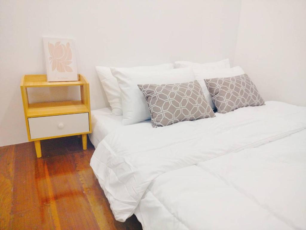 a bedroom with two beds and a night stand at Gamin house hatyai city in Ban Khlong Toei (1)
