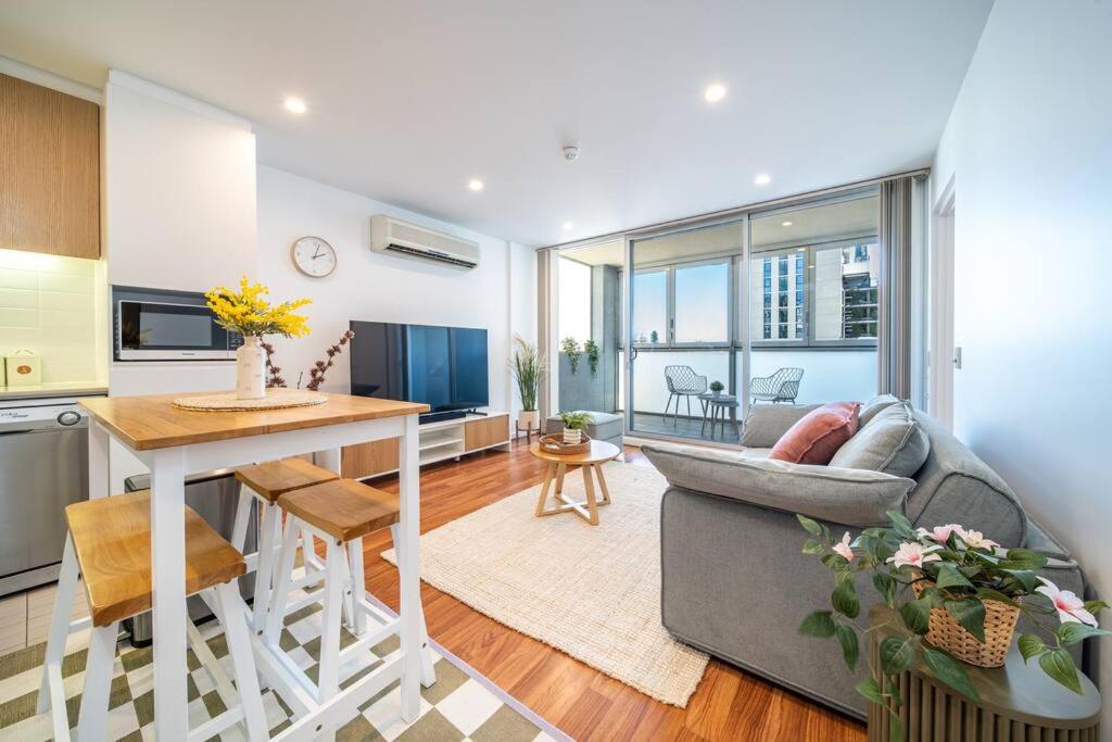 a kitchen and living room with a couch and a table at Wattle on Morphett - Central CBD Convenience in Adelaide