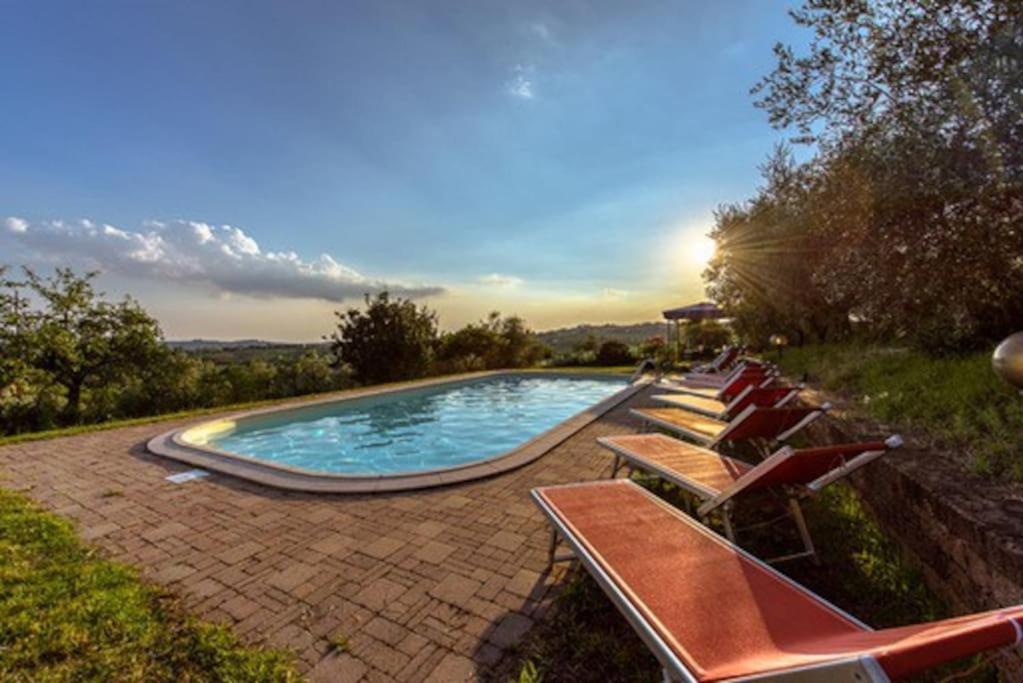 einen Pool mit Liegestühlen und Sonnenuntergang in der Unterkunft Villa Belfiore in Lastra a Signa