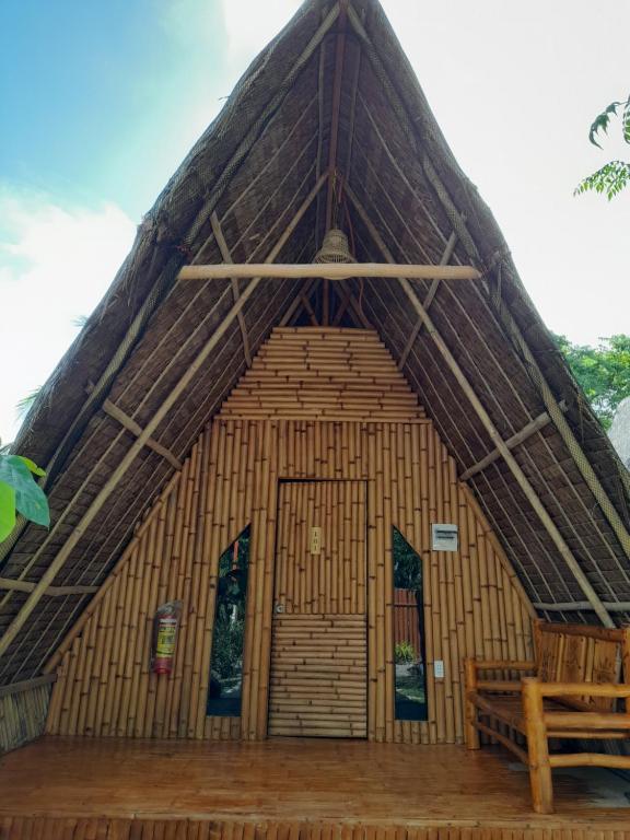 un gran edificio de bambú con techo de paja en Na Wa Cottages, en Panglao