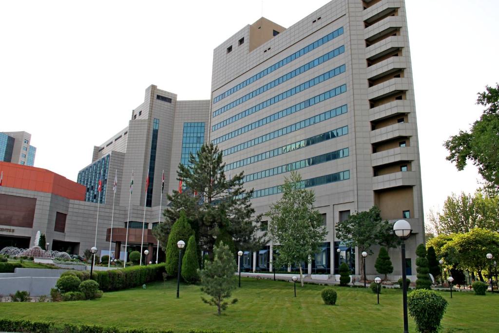 un grande edificio con un parco di fronte ad esso di International Hotel Tashkent a Tashkent