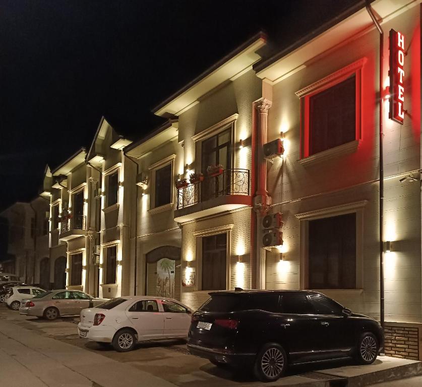 タシュケントにあるGRAND KARAVAN HOTELの夜間の建物前に停車する黒車