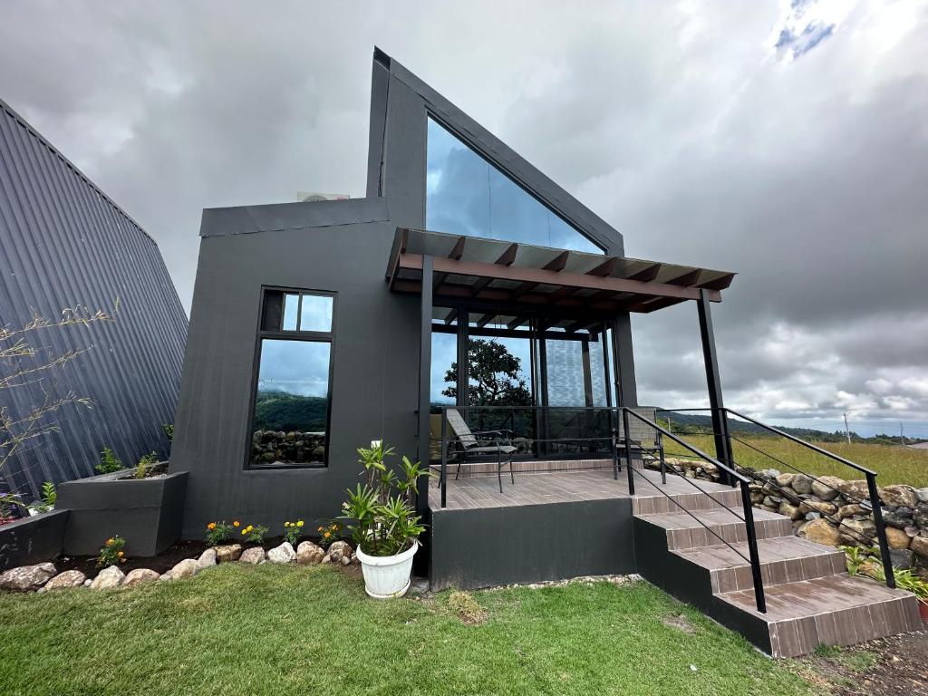 una pequeña casa con puertas de cristal y escaleras en un patio en Suite romántica panorámica en Alto Boquete