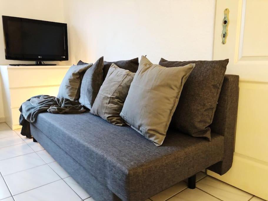 um sofá com muitas almofadas sentado numa sala de estar em Charmante Gartenwohnung mit privatem großen Garten em Colônia