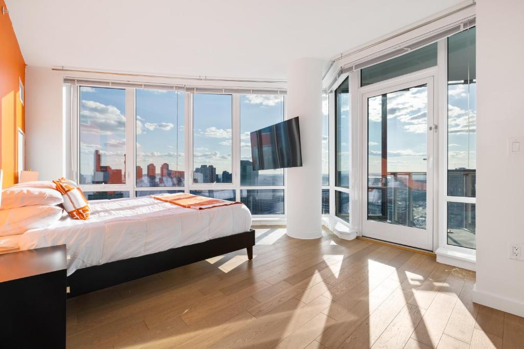 a bedroom with a bed and large windows at Tallest Penthouse in NJ with Wraparound Balcony in Hoboken