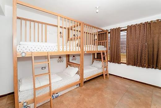 two wooden bunk beds in a room at Jugglers Rest 4 Sharing in Bangalore