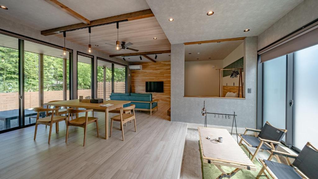 高山的住宿－WAT RESORT 焚火とサウナBBQandリゾートヴィラ 高山，客厅配有木桌和椅子