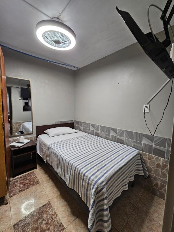 a bedroom with a bed and a light on the wall at Hostal 921 apocento in Arica