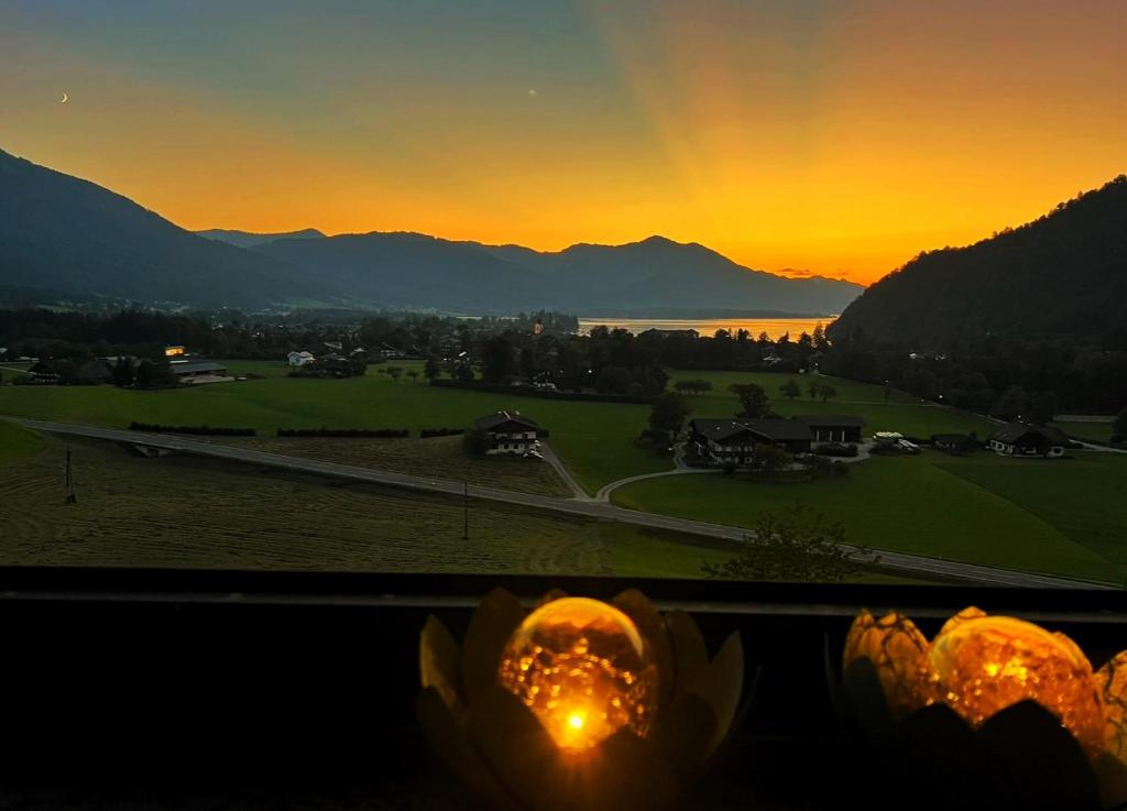 a view of a sunset from a window with pumpkins at Apartment Sunset am Wolfgangsee in Strobl
