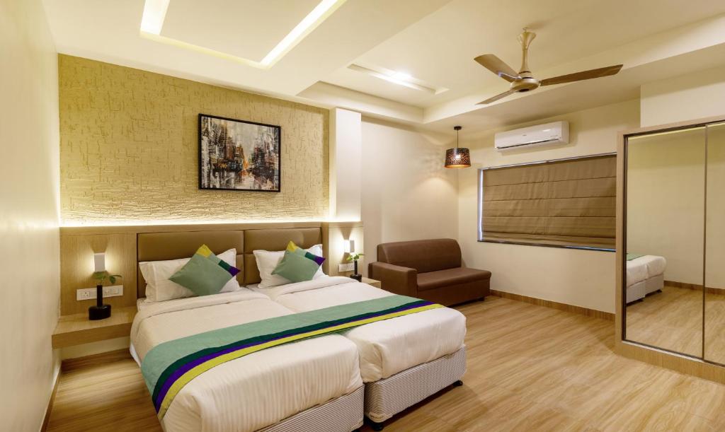 a bedroom with a bed and a chair in a room at Treebo Trend Nestlay Rooms Gummidipoondi in Chennai