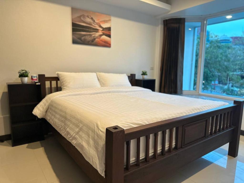 a bedroom with a large bed and a large window at Chris Jay @ CNX in Chiang Mai