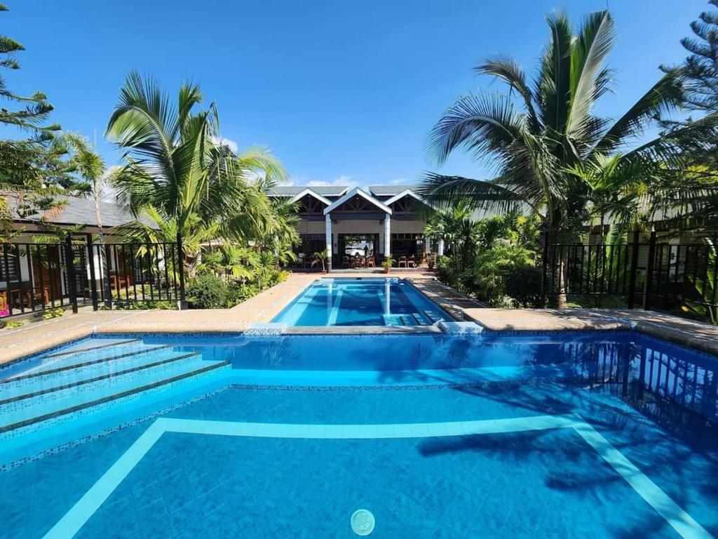 una piscina in un resort con palme di Marand Beach Resort a Bauang