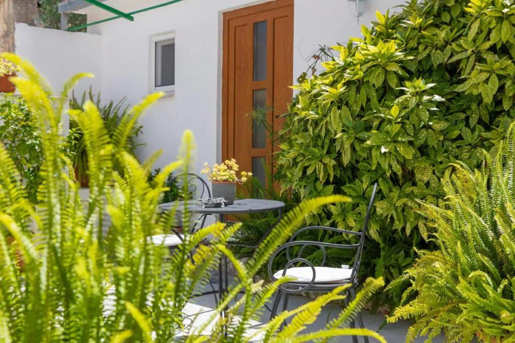 een patio met een tafel, stoelen en planten bij Apartments Stone garden - cosy and comfy in Supetar
