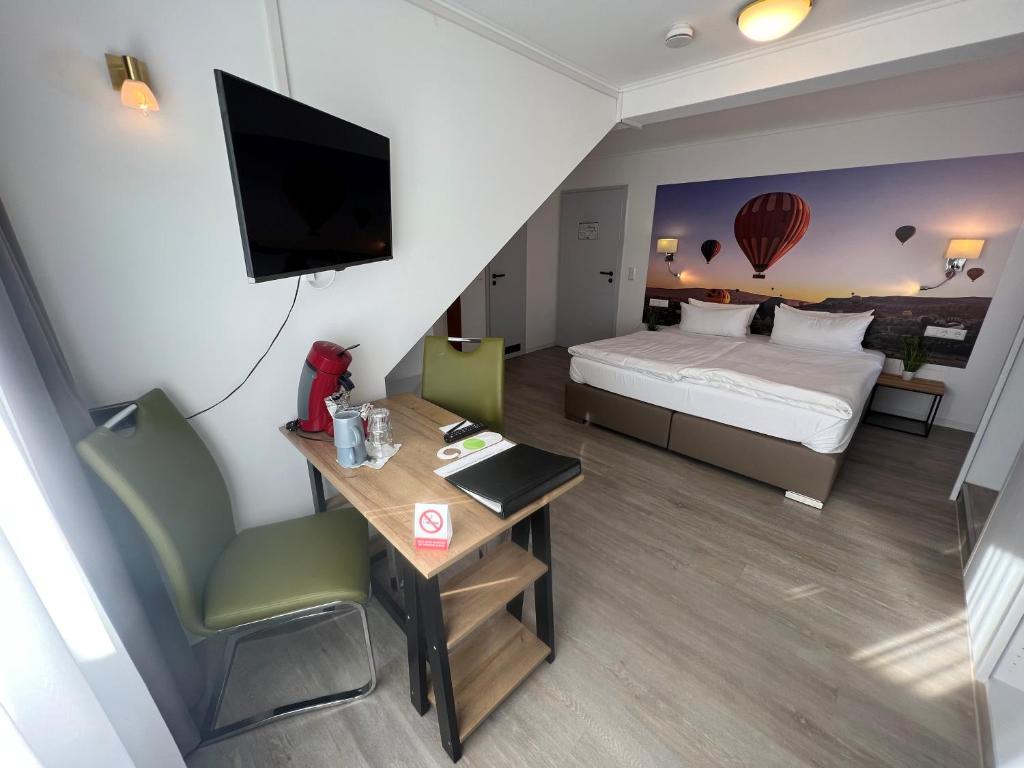 バックナングにあるHotel Bitzer Backnangのベッド、デスク、デスクが備わる小さなホテルルームです。
