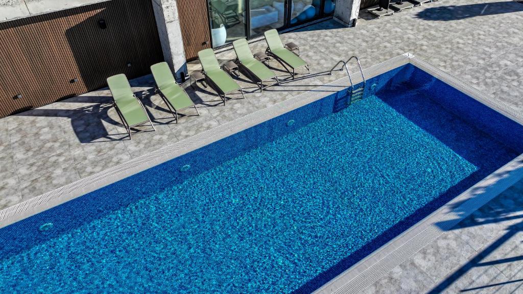 a swimming pool with chairs and a swimming pool at Chateau Mephis Kalaki in Akhalkʼalakʼi