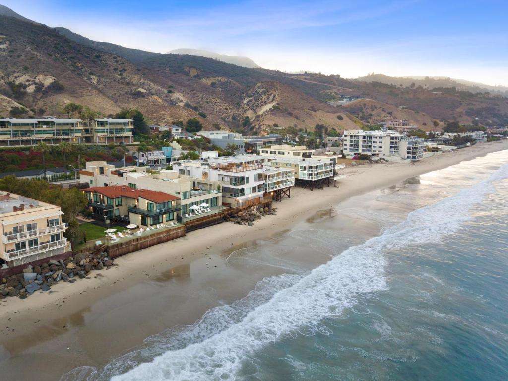 eine Luftaufnahme eines Strandes mit Gebäuden und dem Meer in der Unterkunft Malibu Sand Carbon Beach Suites in Malibu