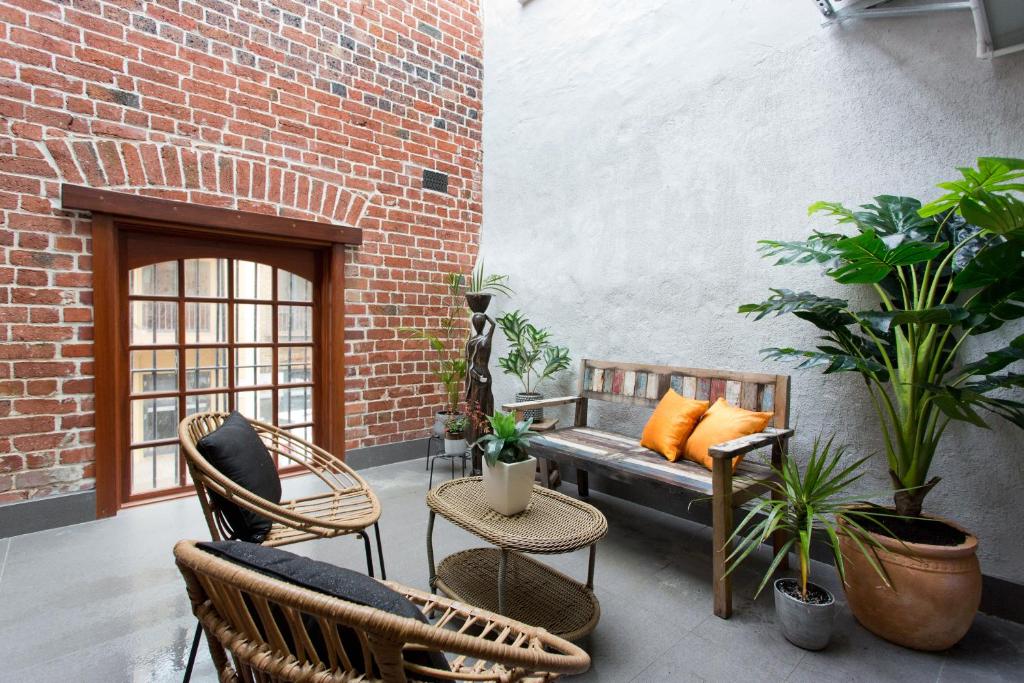 a patio with a bench and chairs and plants at Windows on Pakenham-Hip art space in the West End in Fremantle