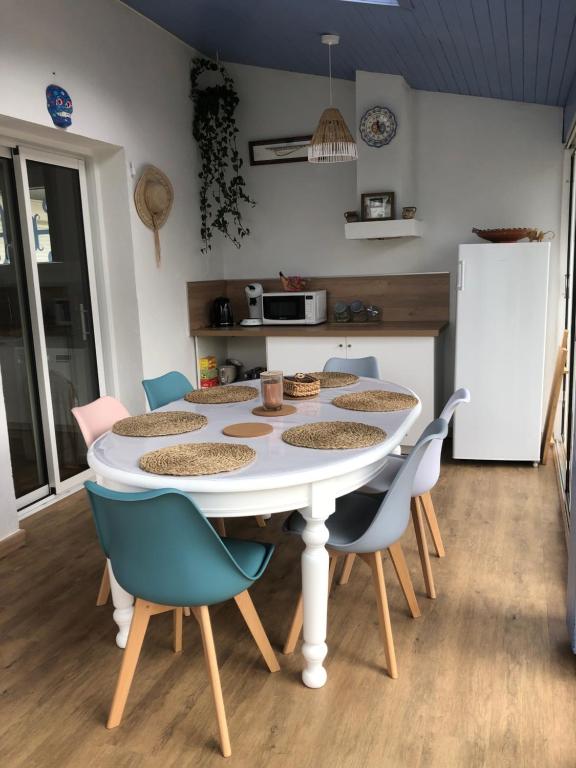 cocina con mesa blanca y sillas en Chambre chez l’habitant en Anglet