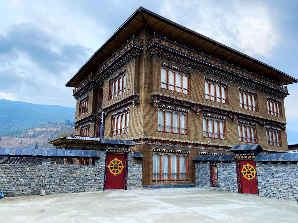 a large brick building with red doors and windows at Paro Eco Lodge in Paro