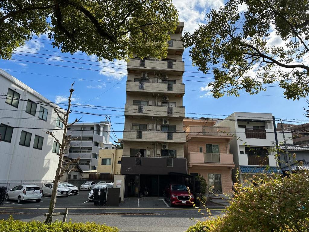 un edificio alto con coches estacionados frente a él en North River 302 Dandelion 新スタジアムの近く en Kami-nagarekawachō