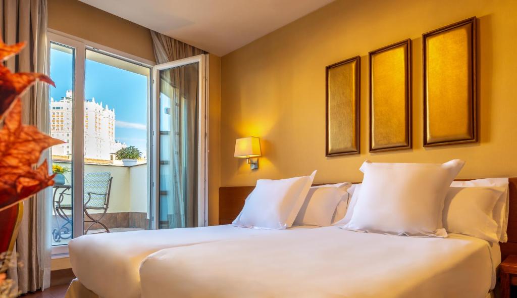 Un dormitorio con una gran cama blanca y una ventana en Sterling, en Madrid