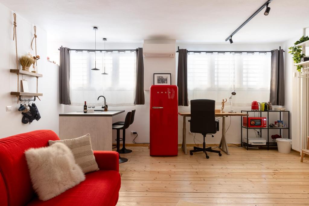 sala de estar con nevera roja y cocina en Appartamento Loft Sandy, en Milán