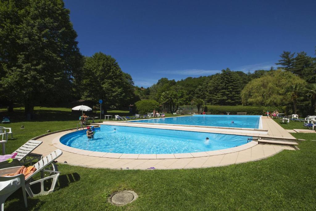 - une grande piscine dans l'herbe avec des gens dans l'établissement France Apartment - Happy Rentals, à Ispra