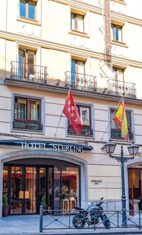 a hotel with two flags in front of a building at Sterling in Madrid
