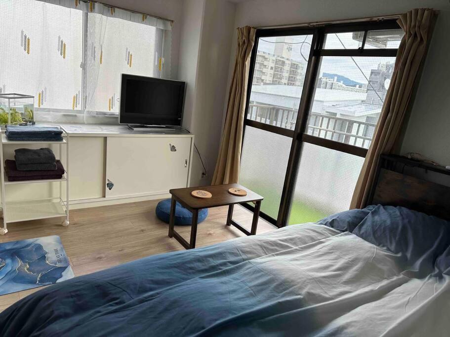 ein Schlafzimmer mit Bett, Schreibtisch und Fenster in der Unterkunft North River 601 Peace Wing 6A in Kami-nagarekawachō